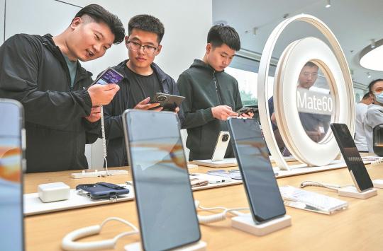 Shoppers look at newly launched smartphones at the Huawei flagship store in Beijing. （KEVIN FRAYER/GETTY IMAGES）