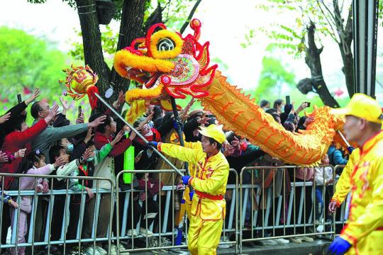 Dragon dance performers interact with spectators at a grand parade in Huizhou during the Lantern Festival on Feb 24. （Photo provided to China Daily）