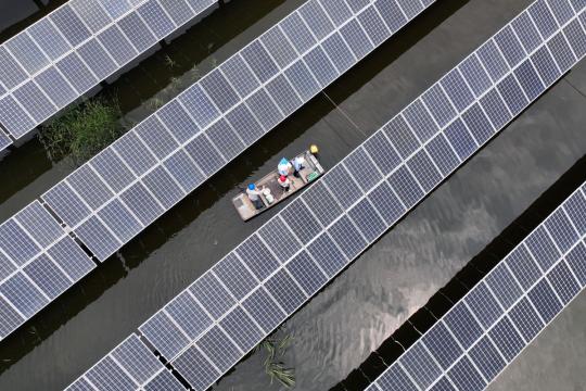 Police officers and electricians inspect a lake-based photovoltaic power station in Baoying county, Jiangsu province, in June. The county has integrated fishing with the PV industry in its green energy transition. [PHOTO by SHEN DONGBING/FOR CHINA DAILY]