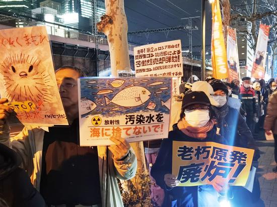 Japanese citizens rally in front of the headquarters of the Tokyo Electric Power Company in Tokyo late on Monday, demanding an immediate cessation of the ocean discharge of nuclear-contaminated water. (JIANG XUEQING / CHINA DAILY)