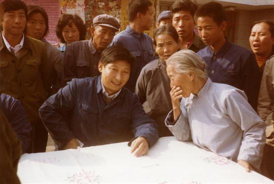 Xi Jinping, then secretary of the Zhengding County Committee of the Communist Party of China (CPC), listens to opinions of villagers in Zhengding County, north China's Hebei Province, in 1983. (Xinhua)
