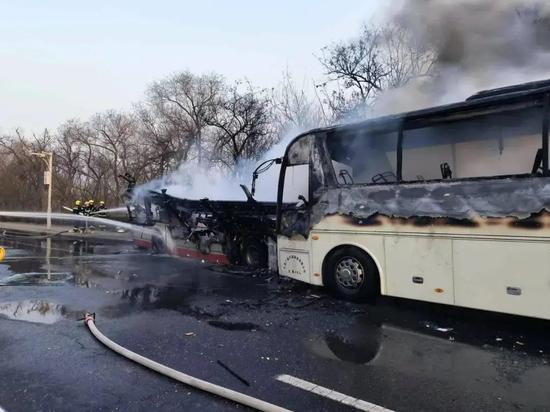 Photo taken on March 15, 2024, shows firefighters spraying water on one of the two buses involved in the accident in Tianjin's Dongli district. (Screengrab/CCTV News app)