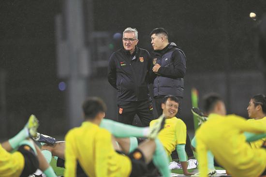 Team China head coach Branko Ivankovic oversees training in consultation with a member of his staff. (Photo/ CHINA DAILY)