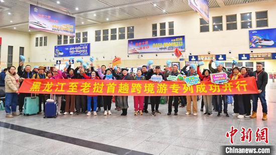 Tourists pose for a group photo at Harbin East Station in Heilongjiang Province, March 28, 2024. ( 
