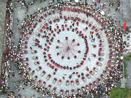 Local ethnic people demonstrate making folk costumes. (Photo provided by Wei Jiyang/For China Daily)