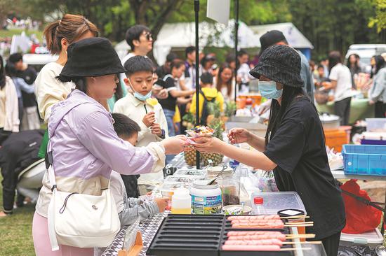 People buy food at the Greater Bay Area Flower Show in Shenzhen on April 8. (Photo for China Daily)