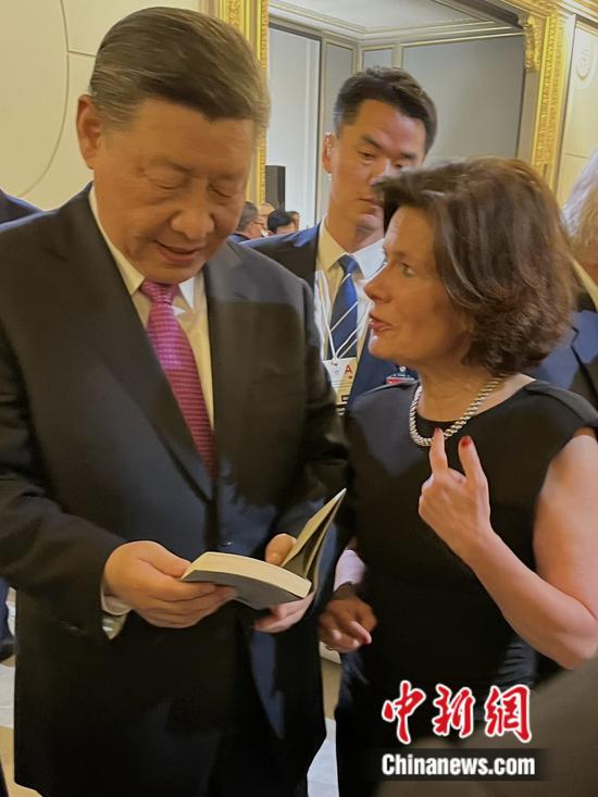 Christine Cayol (R), vice president of Sino-French Cultural Forum, gifts Chinese President Xi Jinping her book at the dinner banquet hosted by French President Emmanuel Macron and his wife Brigitte Macron at the Élysée Palace in Paris, May 6, 2024. (Photo provided to China News Network)