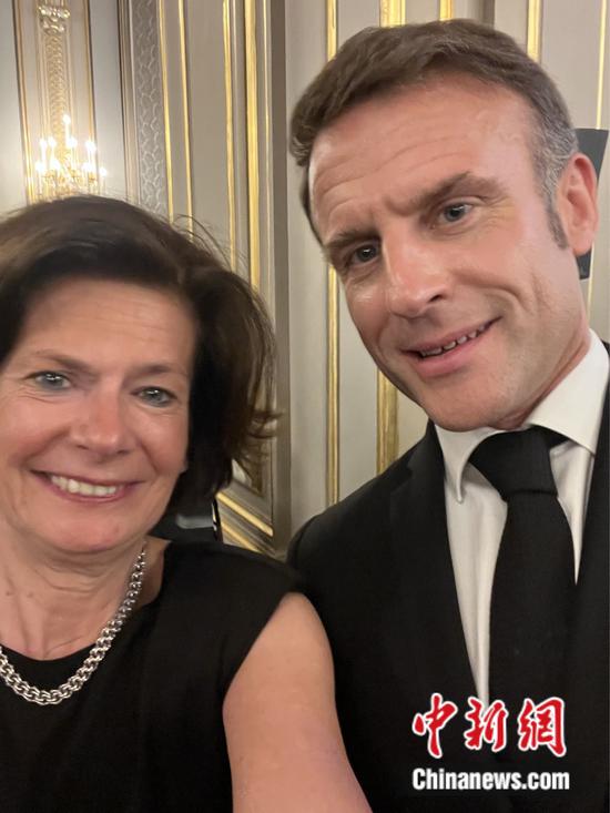 Christine Cayol (L), vice president of Sino-French Cultural Forum, takes a photo with French President Emmanuel Macron at a welcome banquet hosted by the president and his wife Brigitte Macron, at the Élysée Palace in Paris, May 6, 2024. (Photo provided to China News Network)