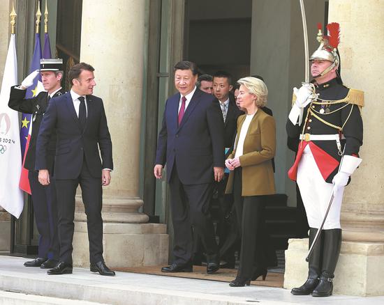 President Xi Jinping (center) walks out of the Elysee Palace in Paris, France, with French President Emmanuel Macron (left) and European Commission President Ursula von der Leyen (right) after a China-France-EU trilateral meeting on Monday. (FENG YONGBIN/CHINA DAILY)