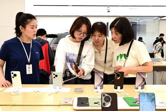 Shoppers try out Huawei's Pura 70 series smartphones at a store in Jinhua, Zhejiang province. (SHI BUFA/FOR CHINA DAILY)