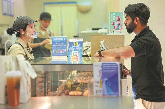 A foreign tourist pays via Alipay at a store in Beijing. (Photo/China Daily)