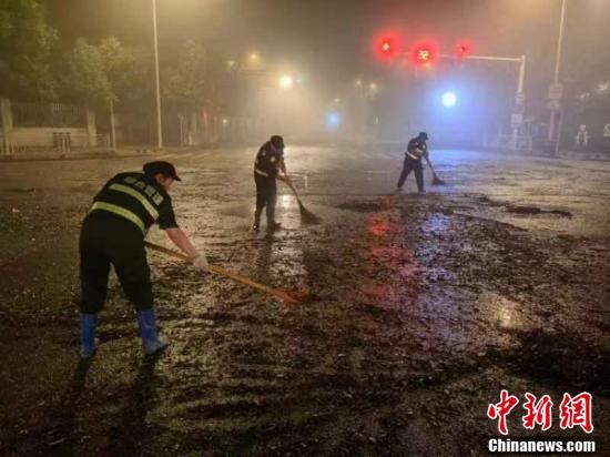 Workers clean a road overnight in Tunxi District of Huangshan City,  Anhui Province  from June 20 to June 21 after the heavy rain hit the city. (Photo provided to China News Service)