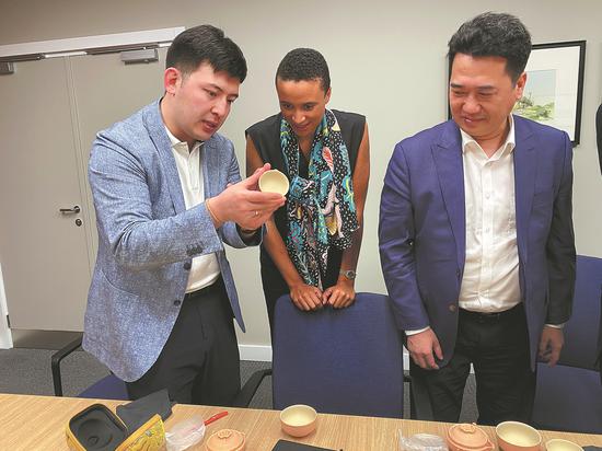 Ruslan Tulenov (left) presents a Chinese ceramic cup during his visit to an HSBC branch in Qormi, Malta, in May. Tulenov, a Kazakh with the rare Rh-negative blood type, is known in China for his generosity in donating blood and his contributions to Hainan province's economic cooperation with the world. (CHINA DAILY)