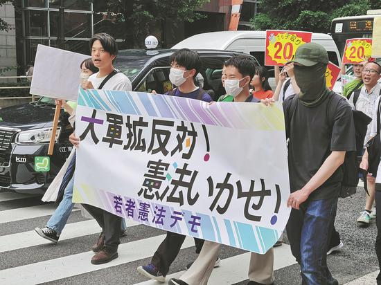 Nearly 300 people stage a protest march in Tokyo on Sunday, opposing the government's massive military buildup and attempts to revise the constitution. (JIANG XUEQING/CHINA DAILY)