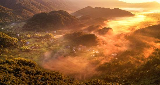 Misty sunrise scenery over village in Sichuan