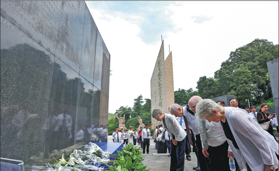 A Flying Tigers delegation from the US pays tribute to anti-Japanese aviation martyrs in Nanjing, in China's Jiangsu province, on Tuesday. On the same day, the memorial hall announced the addition of the name of Jack Hammel, a Flying Tiger pilot, to the monument. (YANG BO/CHINA NEWS SERVICE)