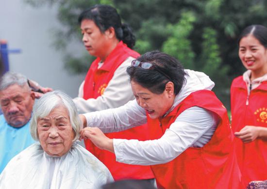 Volunteers give haircuts to seniors at a nursing home in Jiaozuo, Henan province, on Monday. (CHENG QUAN/FOR CHINA DAILY)