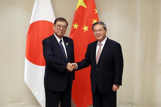 Premier Li Qiang (right) meets with Japanese Prime Minister Shigeru Ishiba in Vientiane, Laos, Oct 10, 2024. (Photo by Wang Zhuangfei/chinadaily.com.cn)