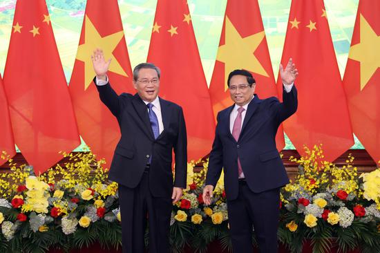 Premier Li Qiang (left) meets on Sunday with Vietnamese Prime Minister Pham Minh Chinh in Hanoi, the capital of Vietnam. The Chinese premier is making an official visit to the Southeast Asian country. (WANG ZHUANGFEI/CHINA DAILY)