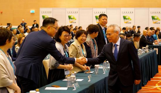 Sam Hou-fai (right), who was elected the chief executive-designate of the Macao Special Administrative Region, shakes hands with a member of the election committee in Macao on Sunday. (ZHENG JIAWEI/CHINA NEWS SERVICE)