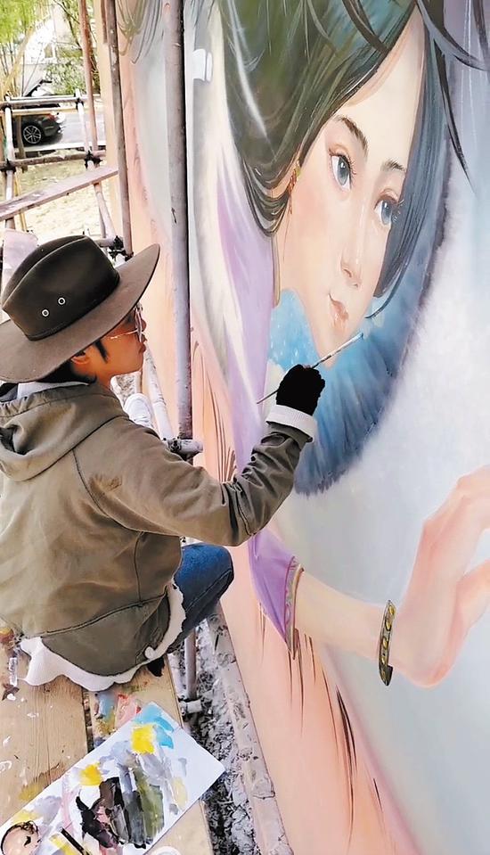 An Nianchu paints a mural on a wall at Cha village in Lhasa, Xizang autonomous region. (Photo/China Daily)