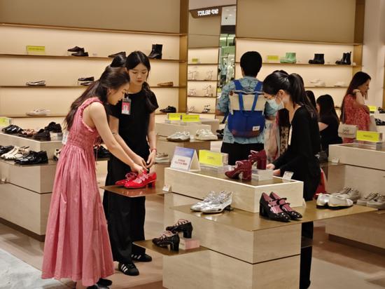 Consumers check out shoes at SKP Wuhan in Hubei province on July 26. [CHINA DAILY]