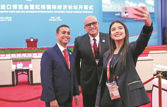 Guests at the seventh China International Import Expo take a selfie before the opening ceremony of the event in Shanghai on Tuesday. The expo runs through Sunday. (ZOU HONG/CHINA DAILY)