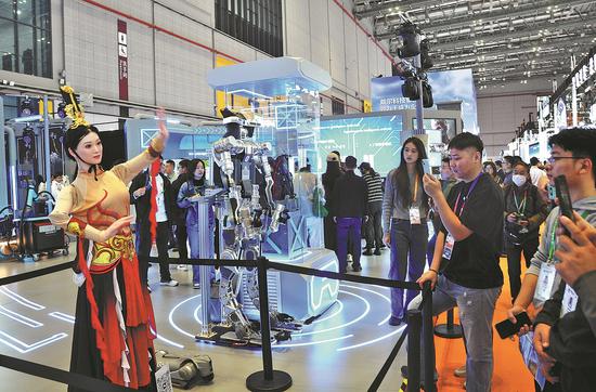 Visitors take photos of a humanoid robot on Saturday at the exhibition area for intelligent industry and information technology during the seventh China International Import Expo in Shanghai. The six-day exhibition ended on Sunday. (YAN DAMING/FOR CHINA DAILY)