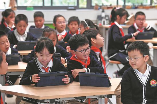 Primary school students use electronic devices during a class in Nanjing, Jiangsu province, on Oct 14. (Photo by Wan Chengpeng/For China Daily)