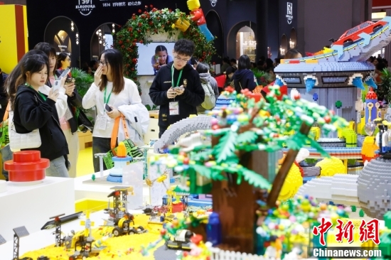 A visitor uses a smartphone to capture toys at the consumer goods exhibition area of the 7th China International Import Expo on Nov. 11.