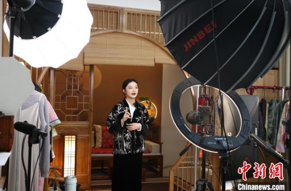 A host, dressed in traditional Chinese-style attire, promotes products on Singles' Day, Nov. 11. (Photo by Xiang Jing)