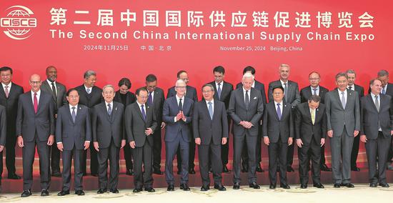 Premier Li Qiang (front row, center) poses for a photo with the representatives of attendees of the second China International Supply Chain Expo before a symposium in Beijing on Monday. The expo, which begins on Tuesday and runs through Saturday in the Chinese capital, is the world's first national-level exhibition focusing on supply chains. (WANG ZHUANGFEI/CHINA DAILY)