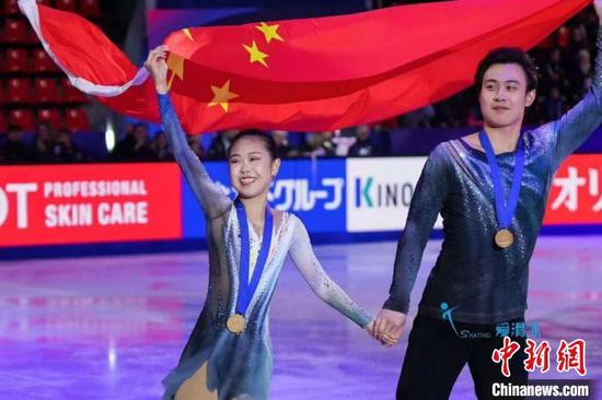 Zhang Jiaxuan and Huang Yihang hold the national flag and walk around the stadium to express their gratitude on Dec. 8, 2024. (Photo provided by Heilongjiang Sports Bureau)