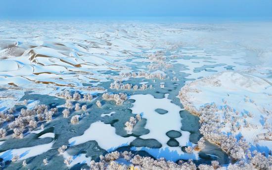 Sand dunes turned to winter wonderland after snow in Xinjiang