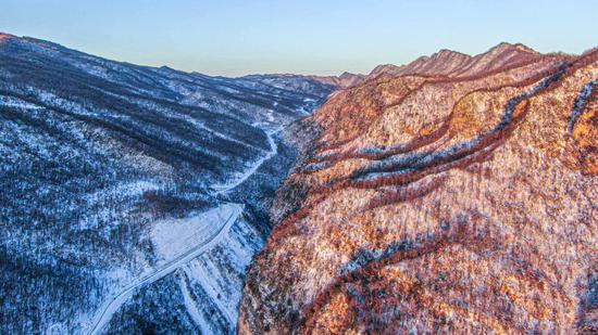 Morning glow adds color to snowy mountain at Shennongjia