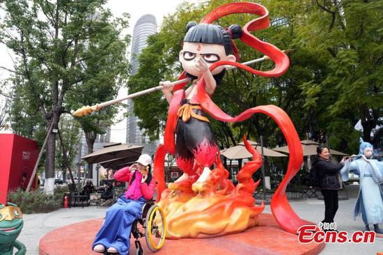 Tourists pose for photos with a "Ne Zha" sculpture in Chengdu, southwest China's Sichuan Province, Feb. 6, 2025. (Photo: China News Service/An Yuan)