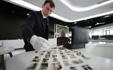 Marcus Detrez displays photos taken by his grandpa, which he believed have documented Japan's atrocities during World War II. (Screenshot Photo)