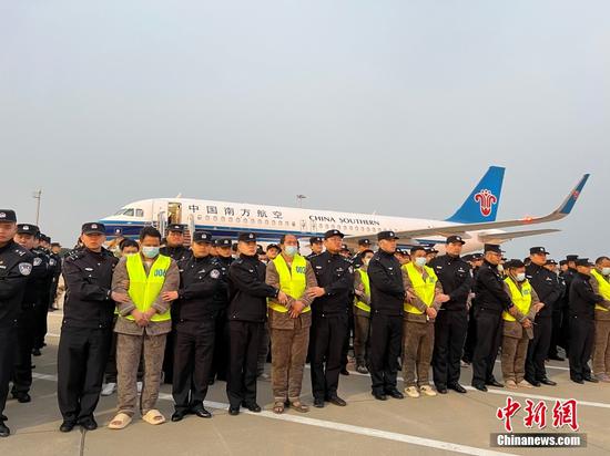 Suspects involved in telecommunications fraud cases are escorted by Chinese police officers as they get off a chartered plane after arriving at Lukou International Airport in Nanjing, Jiangsu province, on Thursday. Photo: China News Service/Guo Chaokai