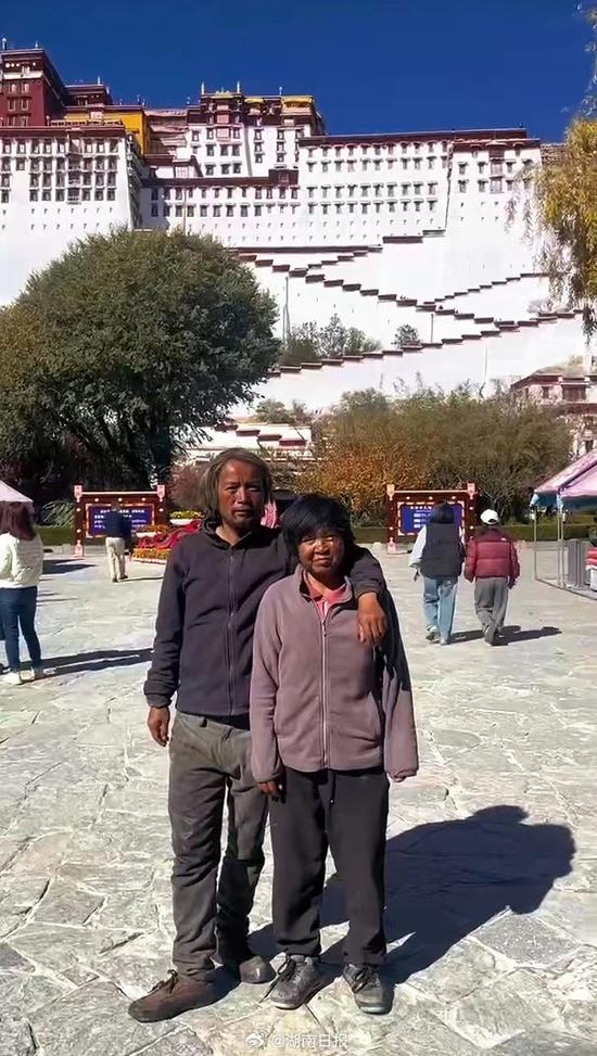 Yang Tongniu and his wife pose for a photo in front of the Potala Palace. (Photo/Hunan Daily) Yang Tongniu and his wife pose for a photo in front of the Potala Palace. (Photo/Hunan Daily)