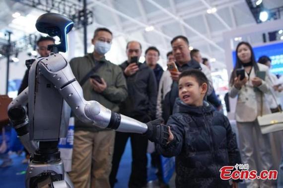A humanoid robot interacts with a boy during the 21st Tianjin Industrial Expo at the National Convention and Exhibition Center (Tianjin), Mar. 6, 2025. (Photo: China News Service/Tong Yu A humanoid robot interacts with a boy during the 21st Tianjin Industrial Expo at the National Convention and Exhibition Center (Tianjin), Mar. 6, 2025. (Photo: China News Service/Tong Yu