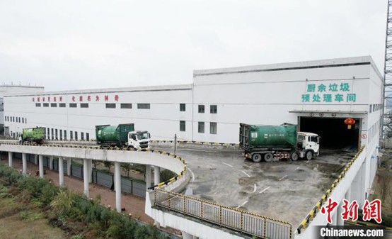 A picture showing garbage trucks entering a kitchen waste treatment plant in an orderly manner for operation. (Photo by Jing Shiyan)