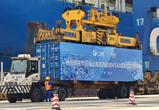 A container vessel loads cargo at Nansha Port in Guangzhou, Guangdong province, on Tuesday as the port launched its first direct shipping route to the west coast of South America. (QIU QUANLIN/CHINA DAILY)