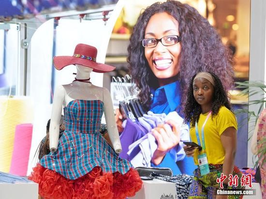An African girl stands beside a model at the fourth China-Africa Economic and Trade Expo at Changsha International Convention and Exhibition Center in Changsha, central China's Hunan Province, June 12, 2025. (Photo/China News Service)