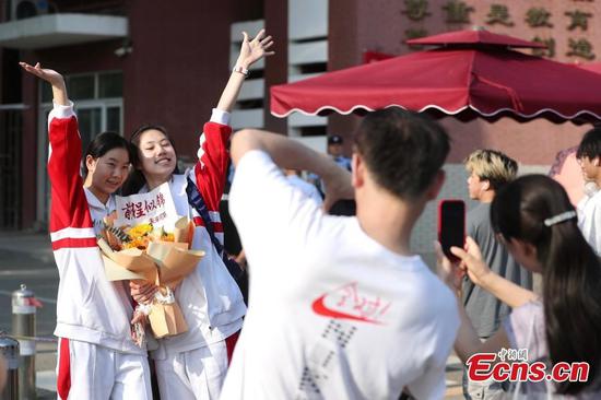 Candidates pose for a photo outside an examination center in Chaoyang District, Beijing, June 10, 2025. (Photo: China News Service/Wang Ziru)