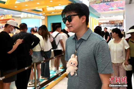 A man wearing a LABUBU visits a store in Beijing, June 13, 2025. (Photo/China News Service)