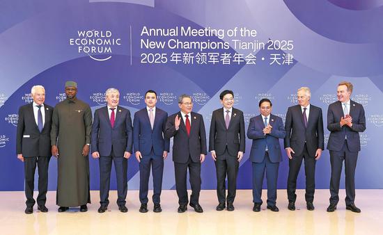 Premier Li Qiang (center) poses on Tuesday for a group photo with foreign leaders attending the 16th Annual Meeting of the New Champions, also known as the Summer Davos, in Tianjin, before a welcoming banquet. (ZOU HONG/CHINA DAILY)