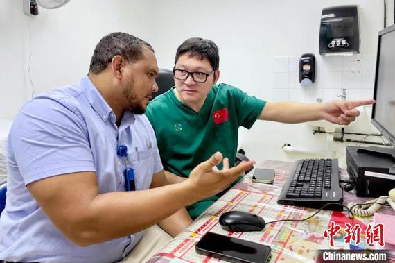 Chinese orthopedic surgeon Wang Fei (R) and his Guyanese counterpart Murillo discuss the surgical plan in Guyana. (Photo/China News Service)