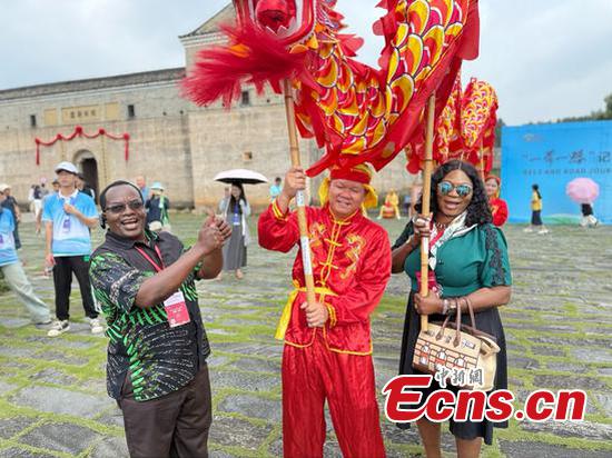 International journalists experience dragon dances in Guanxi Xinwei, a Hakka walled complex in Longnan, east China's Jiangxi Province, July 16, 2025. (Photo: China News Network/ Huang Fang)