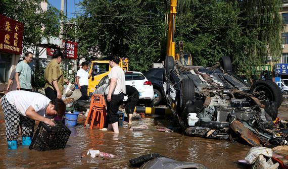 Villagers clean up their belongings on Tuesday as floodwaters recede in Taishitun township in Beijing's Miyun district. (WU XIAOHUI / CHINA DAILY)