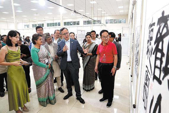 Chen Song (center), Chinese ambassador to Nepal, introduces on Saturday works by Chinese artists to Sujata Koirala (second from left), former deputy prime minister and foreign minister of Nepal, at an exhibition that opened in Kathmandu to mark the 70th anniversary of diplomatic relations between China and Nepal. (CUI NAN/CHINA NEWS SERVICE)